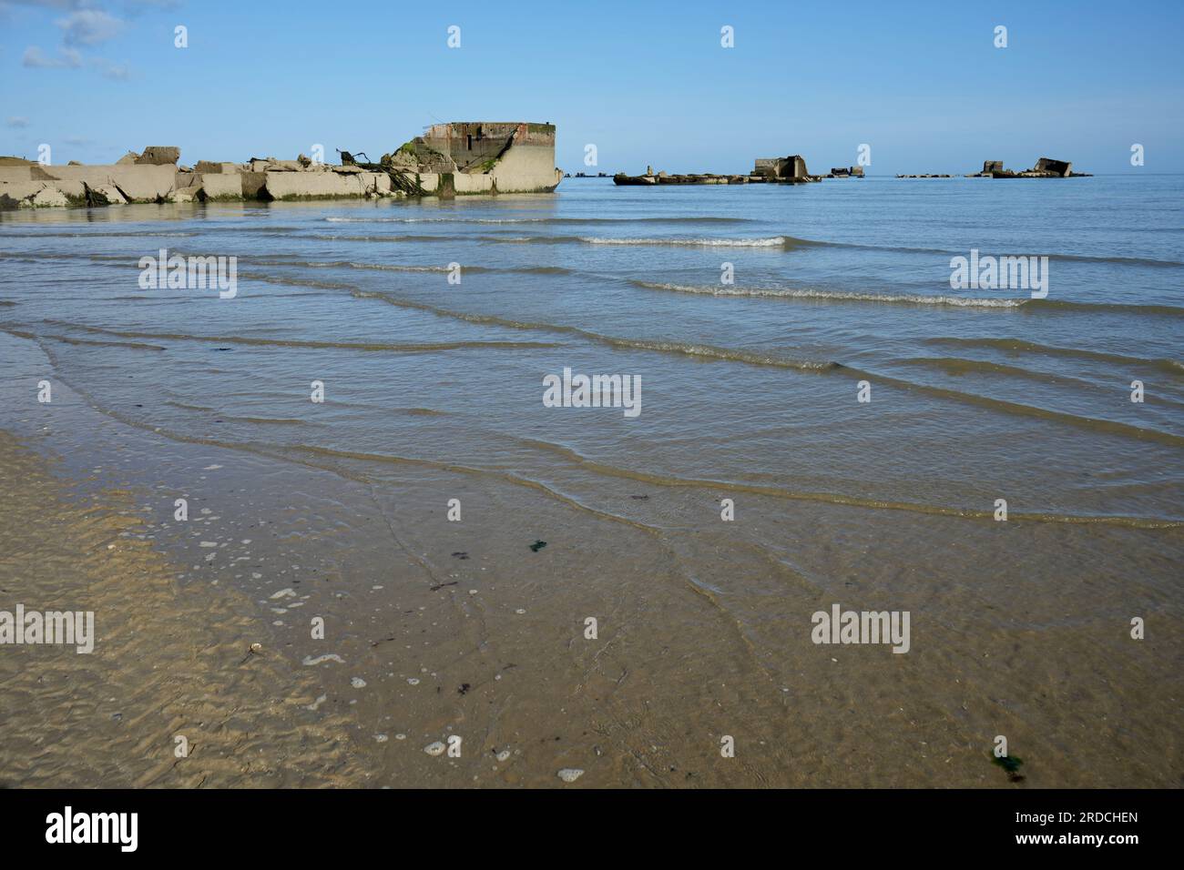 Wellen schlagen am Strand mit Überresten des WW2 D-Day Mulberry Harbour in Asnelles Beach. Arromanches, Frankreich. Stockfoto