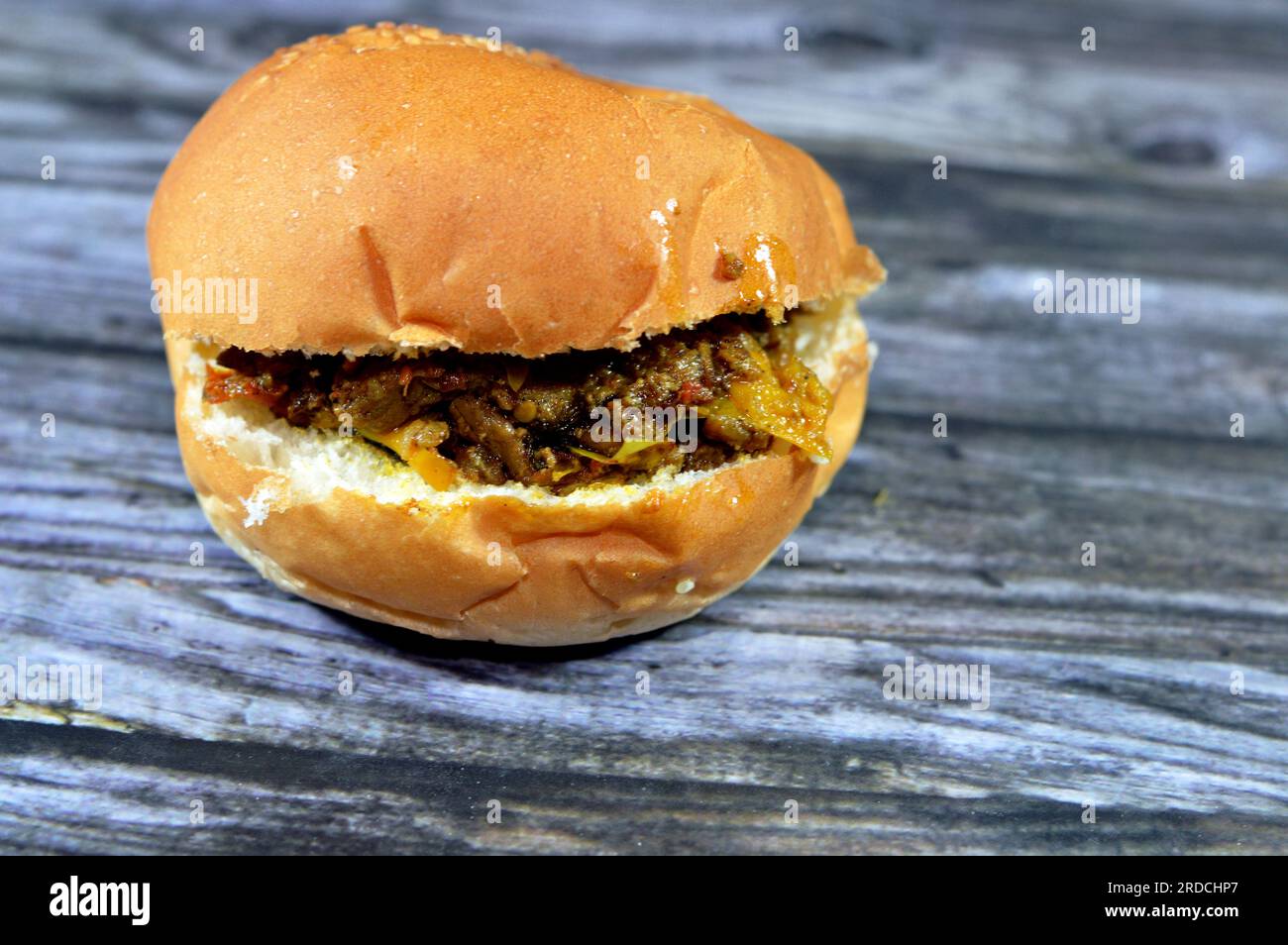 Ein Schawarma-Sandwich mit Rindfleisch in einem Sesambrötchen, einem beliebten Gericht aus dem Nahen Osten, das aus dem Osmanischen Reich stammt, und Fleisch in dünne Scheiben geröstet Stockfoto