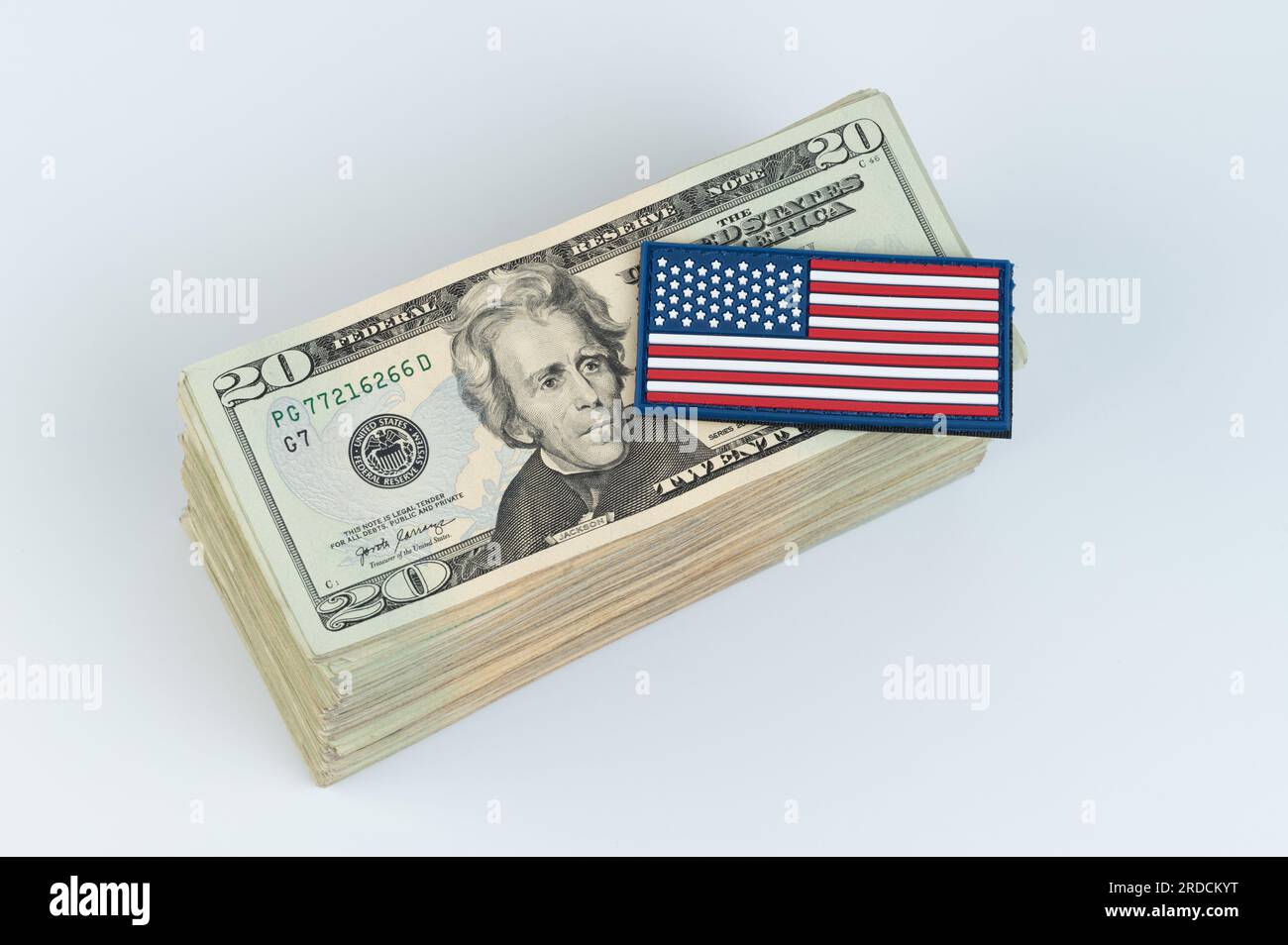 US-Dollar-Scheine mit amerikanischer Flagge auf weißem Studiohintergrund Stockfoto