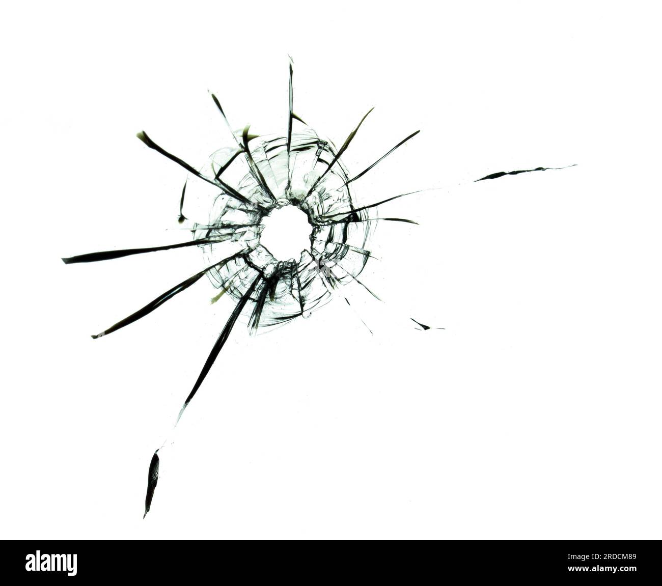 Der Einfluss von Rissen auf Glasscherben aus einem Schuss. Ein Loch im Glas durch eine Kugel, die Folgen des Krieges Stockfoto