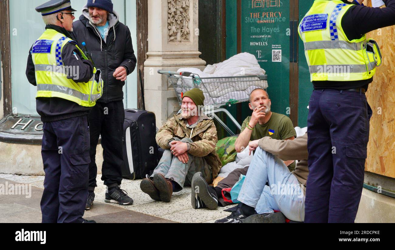 Zwei Polizisten unterhalten sich mit einer Gruppe Obdachloser, die in der Tür eines leeren Kaufhauses von Howells geschlafen haben Stockfoto