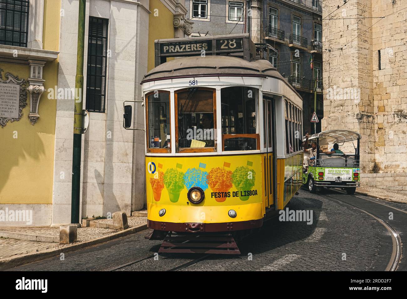 Berühmte gelbe Lissabonner Straßenbahn. Beliebte Straßenbahnlinie 28 im historischen Stadtzentrum von Alfama in Lissabon, Portugal. Stockfoto