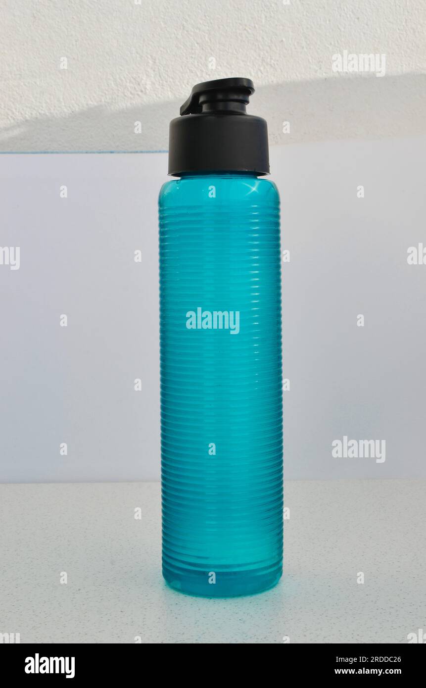Detaillierte Nahaufnahme einer blauen Wasserflasche, perfekt für begleitende Workouts. Essentielle Hydratation für Spitzenleistung. Stockfoto