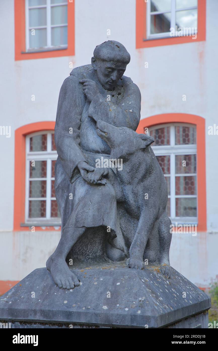 Denkmal und Skulptur des Heiligen Franziskus mit einer Wolfsfigur im ehemaligen Jesuitenkloster St. Johannes Nepomuk, Hadamar, Westerwald, Hessen, Deutschland Stockfoto