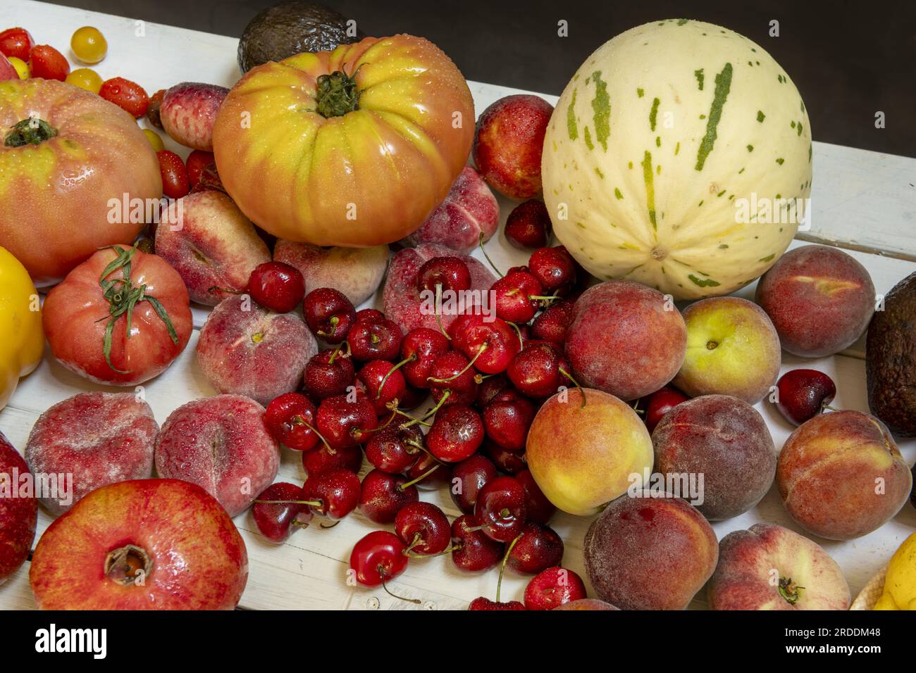 Stillleben mit Melonen, roten Kirschkirschen, Paraguayanischen Kirschen, reifen Tomaten und etwas Obst Stockfoto