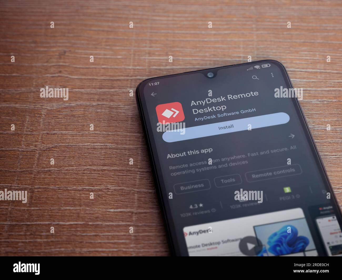 LOD, Israel - Juli 16,2023: AnyDesk App Play Store-Seite auf Smartphone auf Holzhintergrund. Draufsicht flach liegend mit Platz für Kopien. Stockfoto