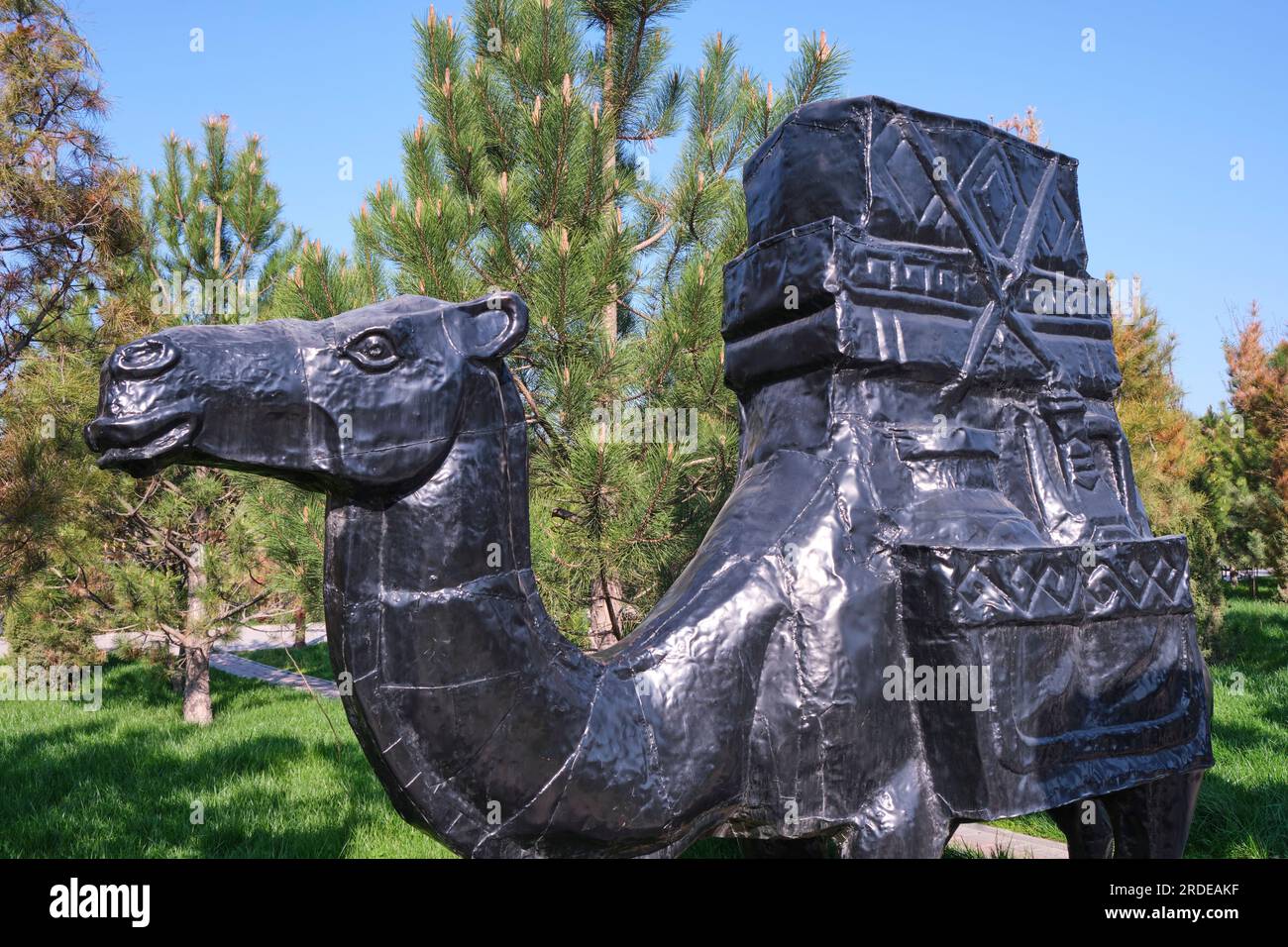 Nahaufnahme, Detailansicht eines typischen Kamels mit Gütern, Fracht, Kisten bei der Caravan Silk Road Skulpturenprozession. Im Ethno Historic Complex Park Stockfoto