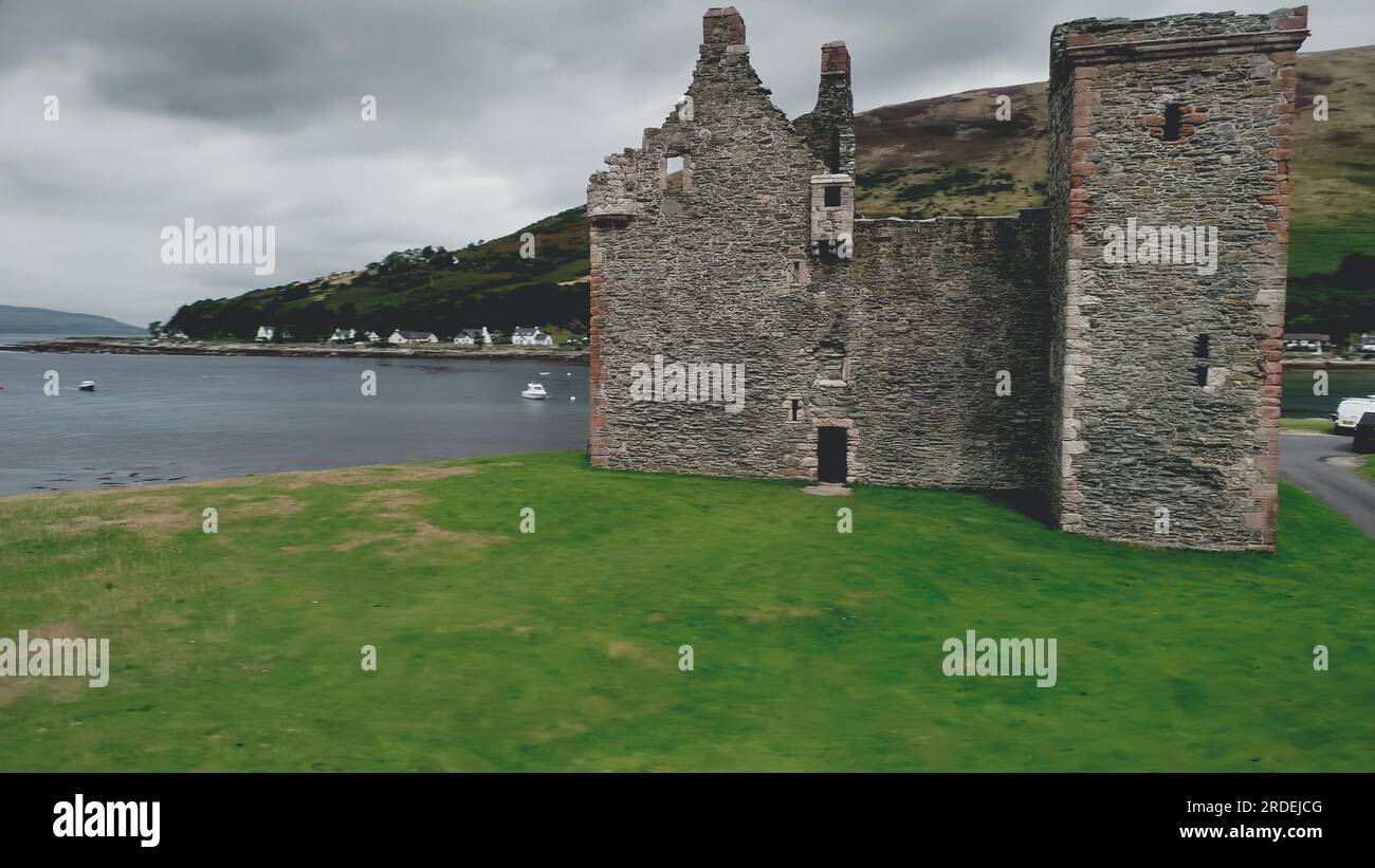 Eine Nahaufnahme von Schottlands Burgruine ist eine Luftaufnahme in der Bucht von Loch Ranza. Historisches Denkmal und Erbe der britischen Kultur. Atemberaubende Landschaft an der Küste von Arran Island, Großbritannien. Filmansicht Stockfoto