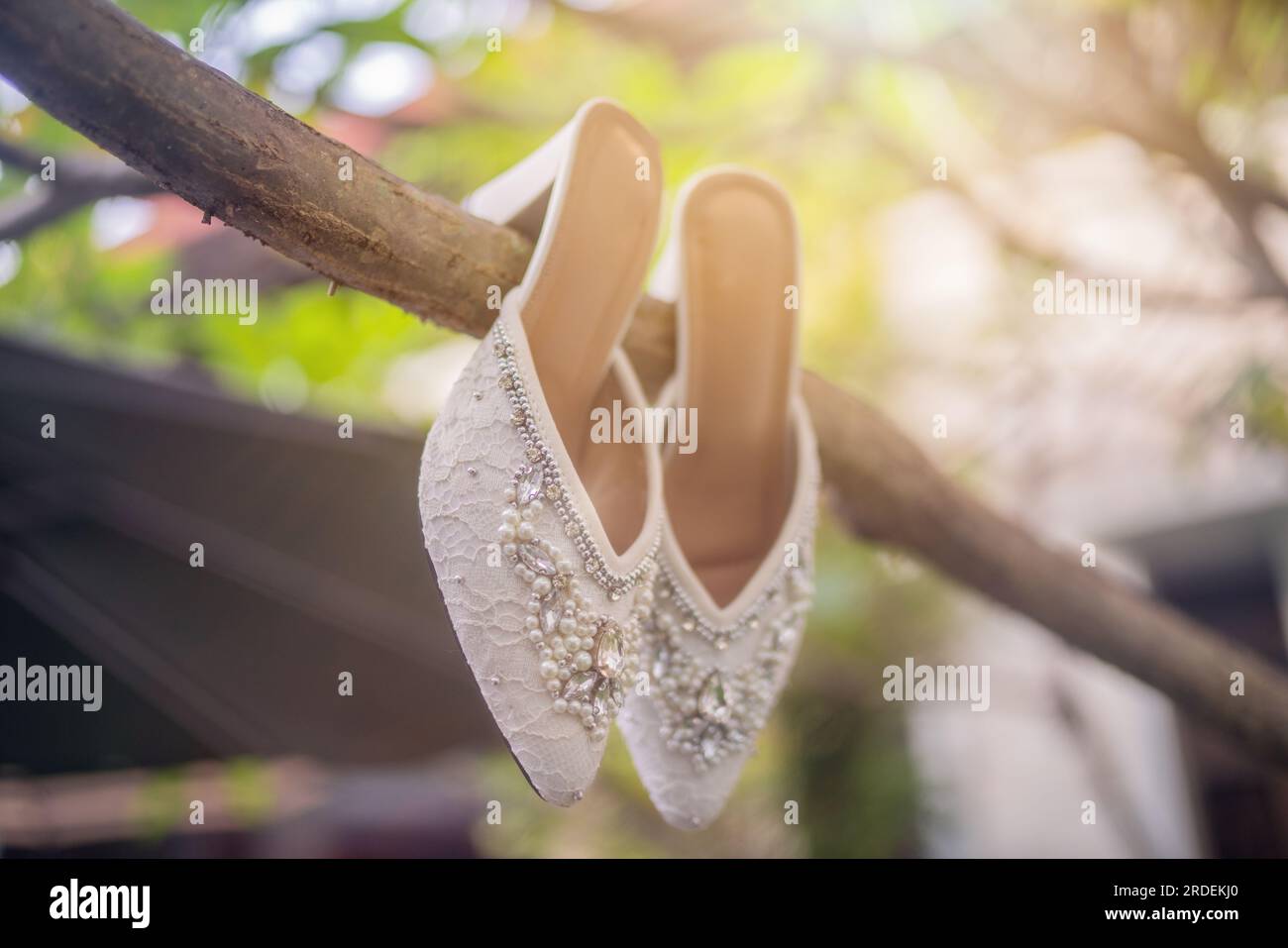 Hochzeitsschuhe mit spitzen Zehen. Schuhe mit hohen Absätzen. Frauenfüße in luxuriösen Sommerschuhen für Damen. Elegante Hausschuhe für Damen auf dem Boden. Fash Stockfoto