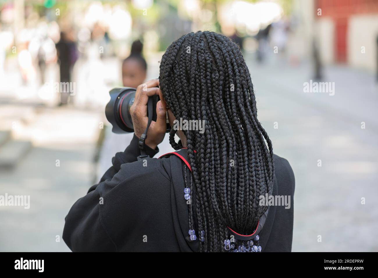 Ein junges Mädchen mit schwarzen Dreadlocks, das ein Foto macht, Paris, Frankreich Stockfoto