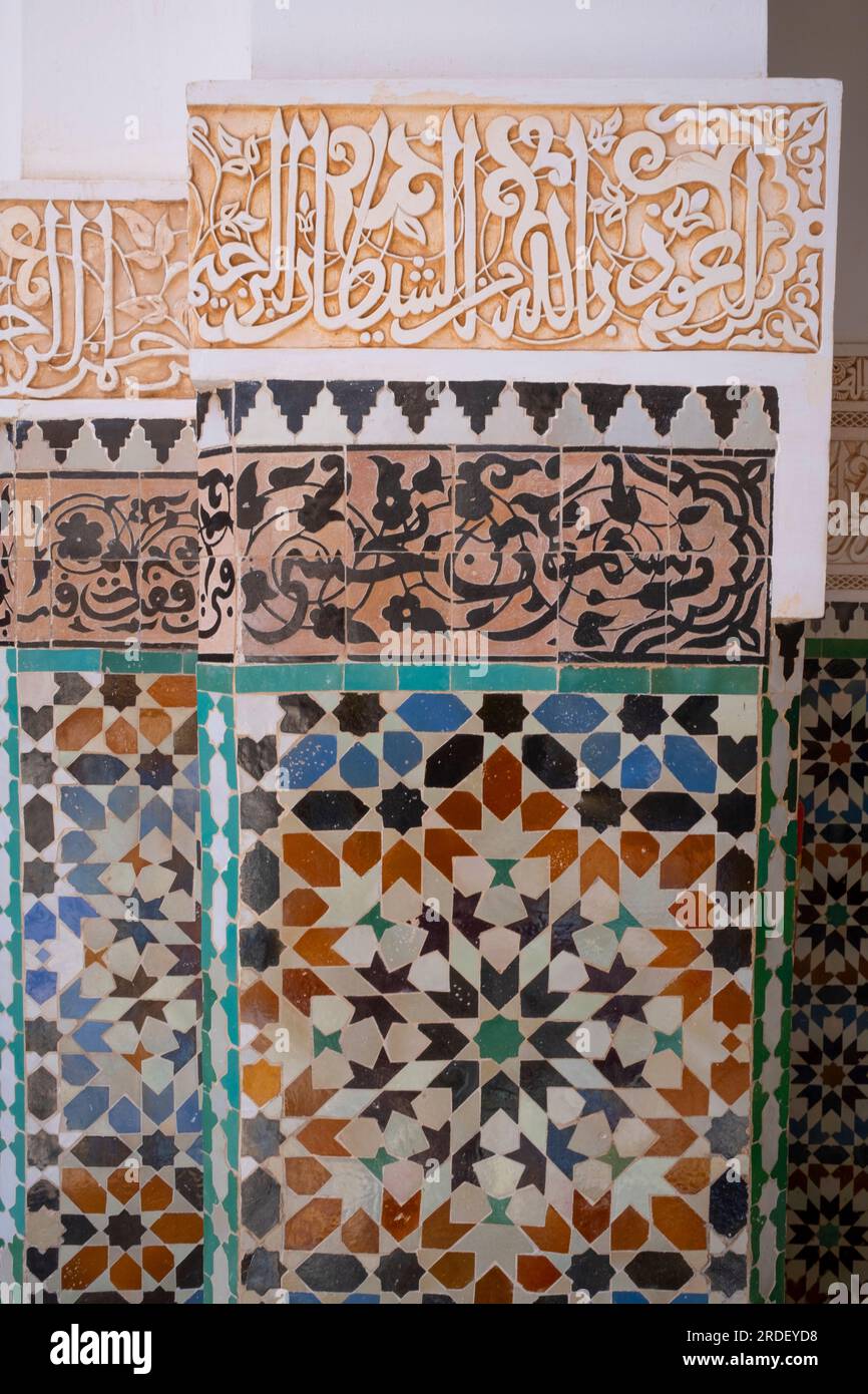 Marokko: Dekorative Zellij-Mosaikfliesen (unten) mit Koranversen (oben), Ben Youssef Madrasa (Medersa Ben Youssef), Medina von Marrakesch, Marrakesch. Der Sultan der Saadier-Dynastie, Abdallah al-Ghalib Billah (1517 - 1574), baute die Madrasa im Jahr 1565 (972 AH). Es war einst das größte islamische College im Maghreb (Nordwestafrika). Stockfoto