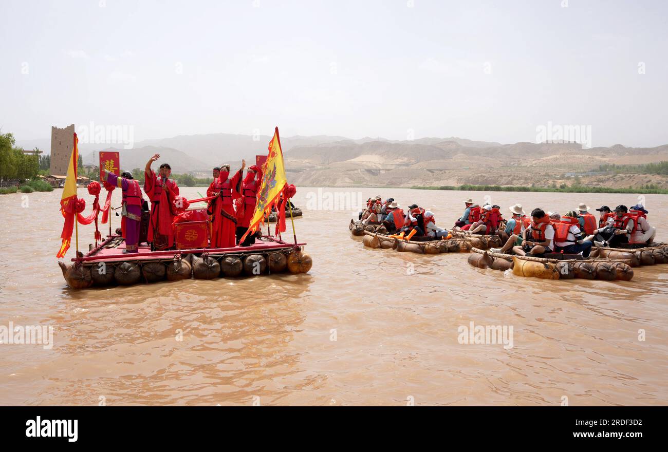 Zhongwei, Chinas autonome Region Ningxia Hui. 20. Juli 2023. Schauspieler veranstalten „Hochzeitszeremonie auf Schaffell-Flößen“ am malerischen Ort Shapotou in Zhongwei, Nordwestchina, Autonome Region Ningxia Hui, am 20. Juli 2023. Shapotou malerischer Ort in Zhongwei im Nordwesten Chinas Ningxia ist während der Sommerferien in die Hauptsaison des Tourismus eingetreten, mit dem größten täglichen Besucherstrom von über 10.000 Besuchern. Kredit: Wang Yuguo/Xinhua/Alamy Live News Stockfoto