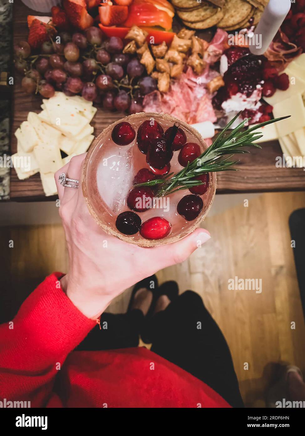 Cranberry Cocktail in der Hand mit Wurstplatte Stockfoto