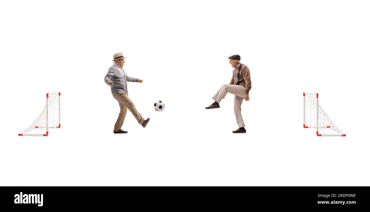Senioren, die Fußball spielen, mit kleinen Toren, isoliert auf weißem Hintergrund Stockfoto