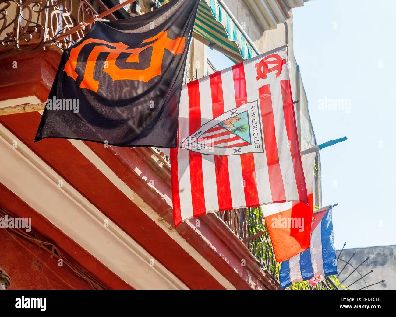 Havanna, Kuba - 27. Mai 2023: Verschiedene Flaggen hängen auf einem Balkon des Hauses. Zwei Textilsymbole gehören zu Sportvereinen. Eine weitere ist die kubanische Nationalflagge Stockfoto