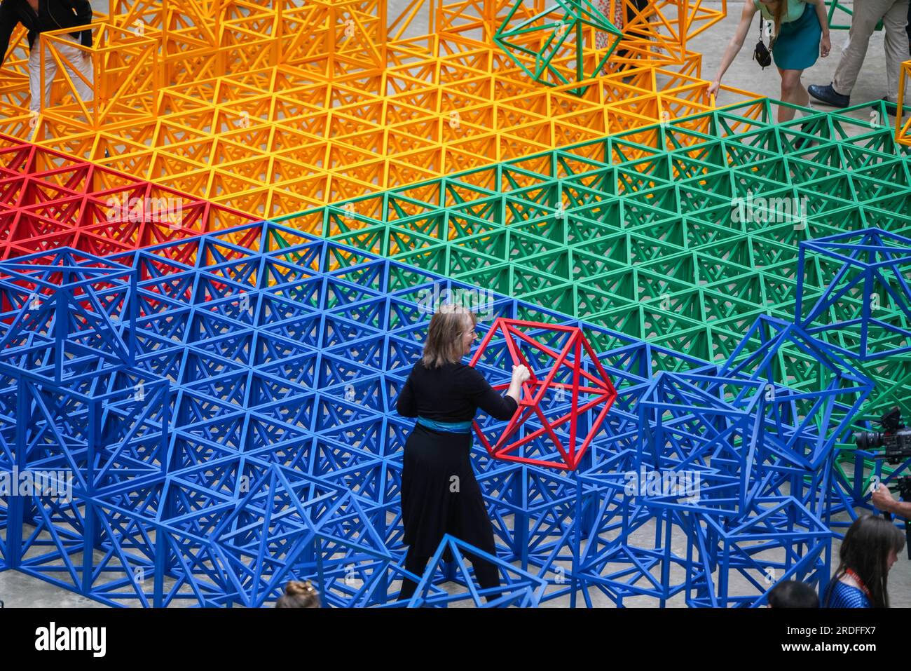 London UK. 21. Juli 2023: Große interaktive Skulptur des britisch-pakistanischen Künstlers Rasheed Araeen in der Turbinenhalle in Tate Modern. Besteht aus 400 Gitterwürfeln in einem 20x20-Gitter, die blau, gelb, grün und rot gestrichen und in einem Quadrat auf dem Galerieboden angeordnet sind. Besucher sind eingeladen, die symmetrische Anordnung zu brechen, indem sie die Struktur verschieben und neu konfigurieren. Die Ausstellung findet vom 22. Juli bis 28. August statt. Credit amer Ghazzal/Alamy Live News Stockfoto