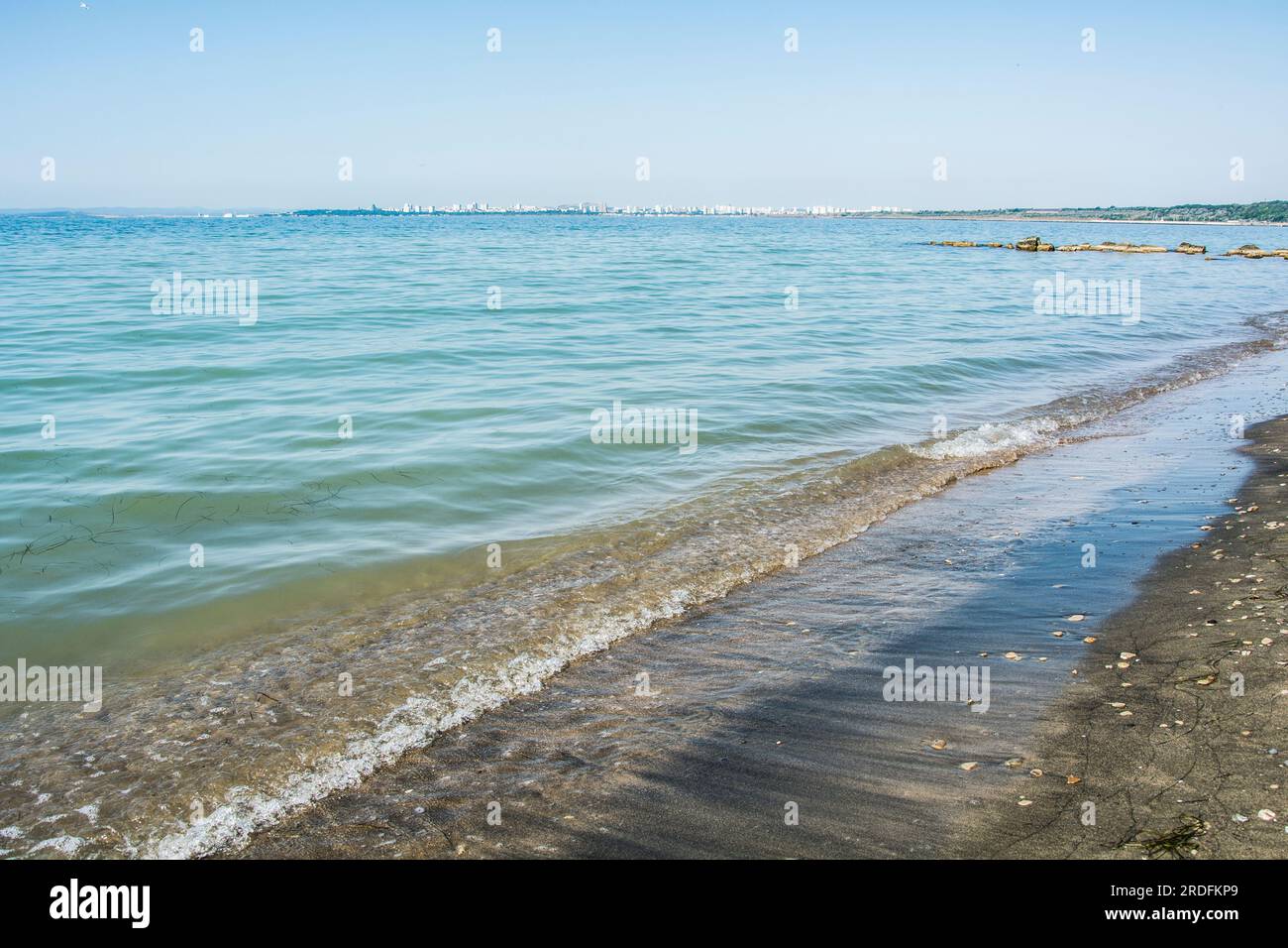 Ruhiges Schwarzes Meer in der Nähe von Sarafovo und dem berühmten schwarzen Sand, der in der Region Burgas in Bulgarien üblich ist. Horizontales Panoramabild Stockfoto