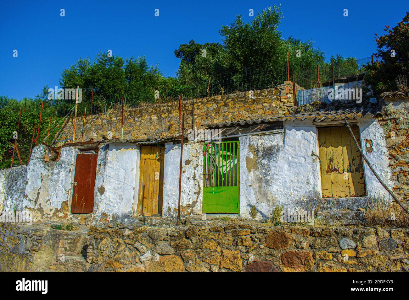 Alte verfallene Schuppen, farbenfrohe bemalte Türen. La Muela, Cádiz, Spanien. Stockfoto