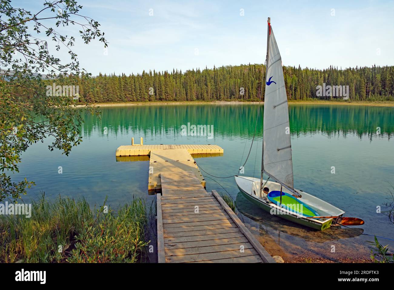 Kleines Boot und Anlegestelle auf einem See mit kristallklarem Wasser, Boya Proinvial Park, Stewart Cessiar Highway, British Columbia, Kanada Stockfoto