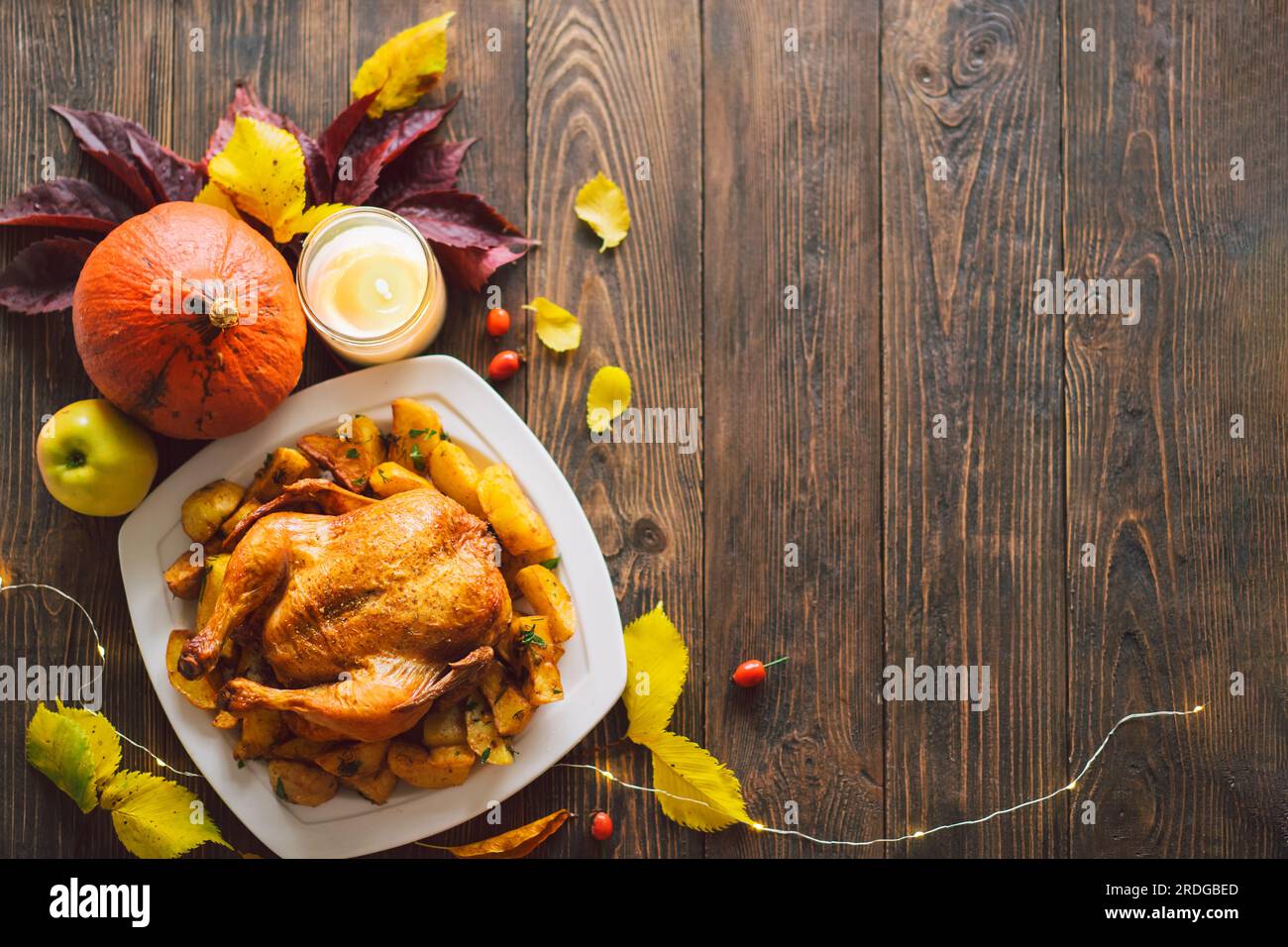 Herbstkomposition mit Blättern, reifem Kürbis und Thanksgiving-truthahn auf einem dunklen Holztisch. Stockfoto