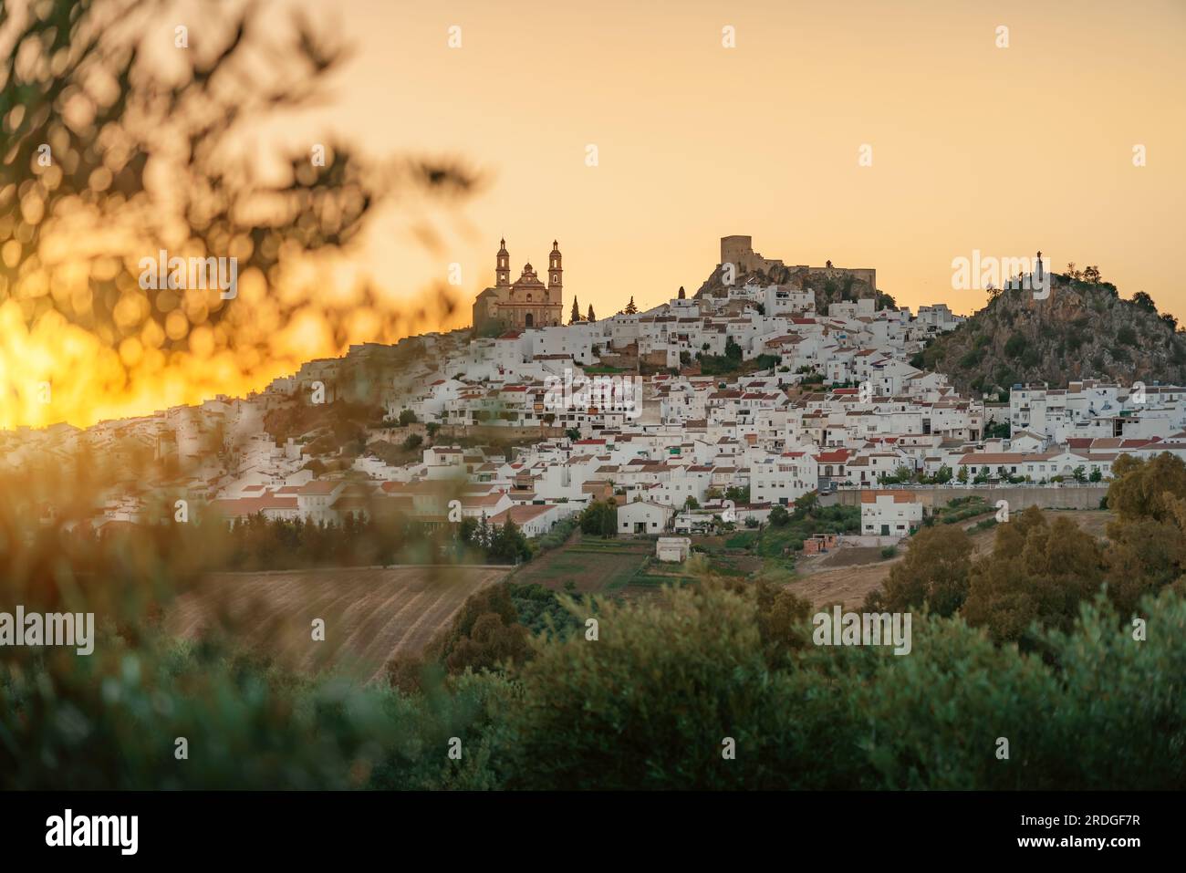 Skyline von Olvera bei Sonnenuntergang mit Kirche, Schloss und Penon del Sagrado Corazon - Olvera, Andalusien, Spanien Stockfoto