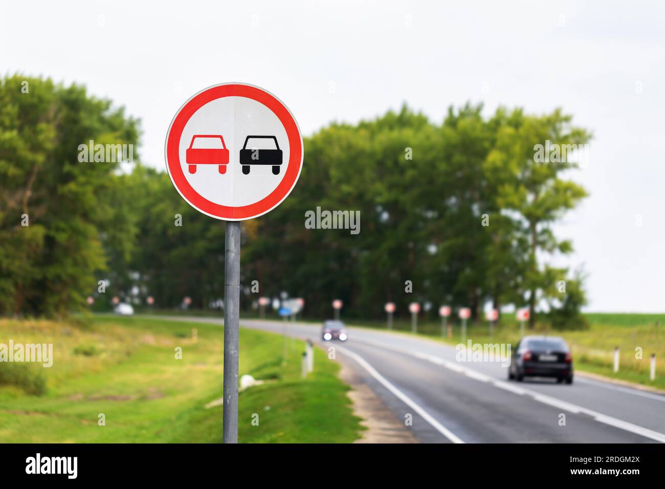 Das Überholschild ist auf einer Autobahn mit vorbeifahrenden Autos verboten Stockfoto