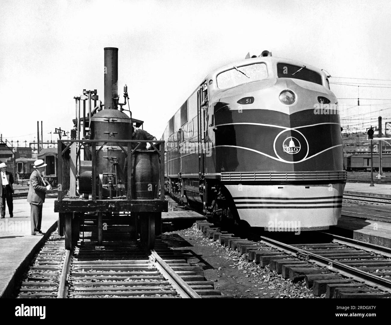 Washington, D.C. Am 25. Mai 1937 werden die ältesten und neuesten Züge an der Union Station gezeigt. Auf der linken Seite befindet sich die Tom Thumb-Lok, die beim ersten Einsatz im Jahr 1829 mit 10 km/h gefahren ist. Daneben befindet sich der neueste Dieselmotor der Baltimore & Ohio Railroad, der den Capitol Limited Pullman Zug zwischen Washington und Chicago mit 75 km/h fährt. Stockfoto