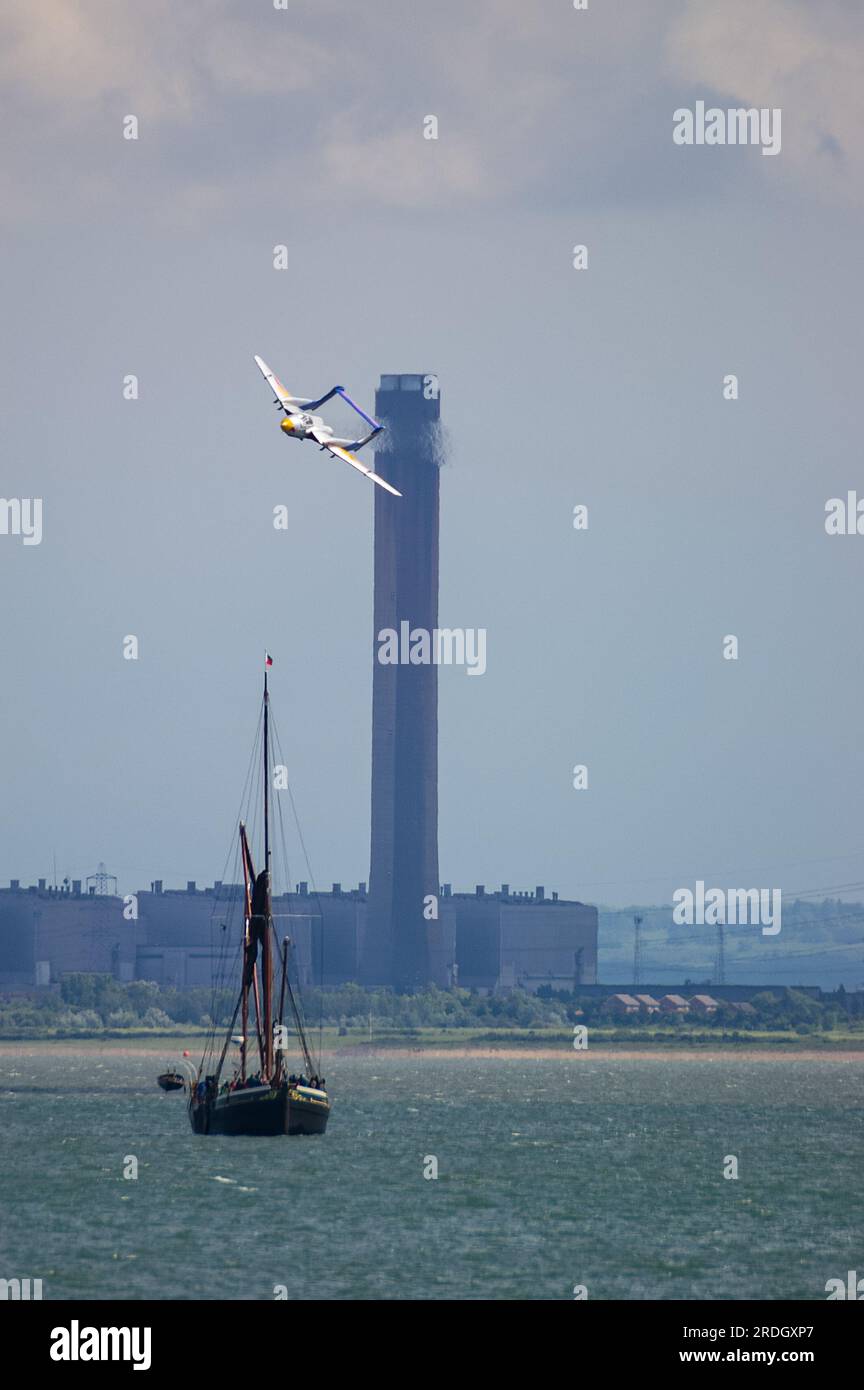 De Havilland Sea Vixen klassisches Düsenflugzeug, das tief über die Themse fliegt, für die Southend Airshow mit Kornkraftwerk, Kamin und Themsenschiff Stockfoto