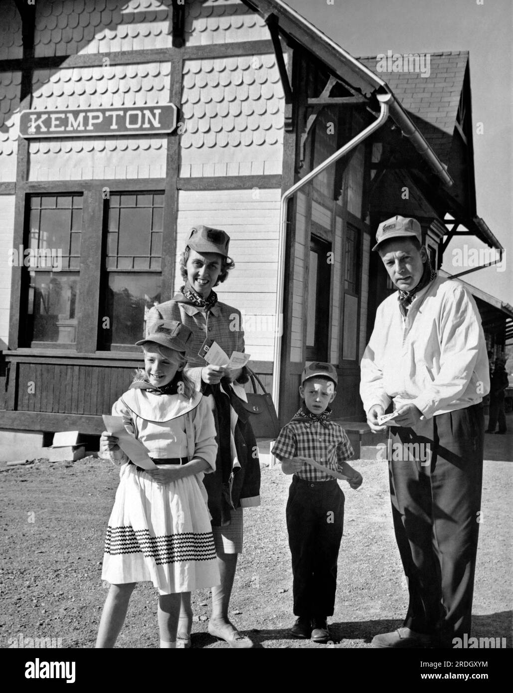 Kempton, Pennsylvania: c. 1963 Eine vierköpfige Familie hat die Tickets und die Schutzkappen des Ingenieurs und wartet am Bahnhof auf eine Fahrt mit dem Zug. Stockfoto