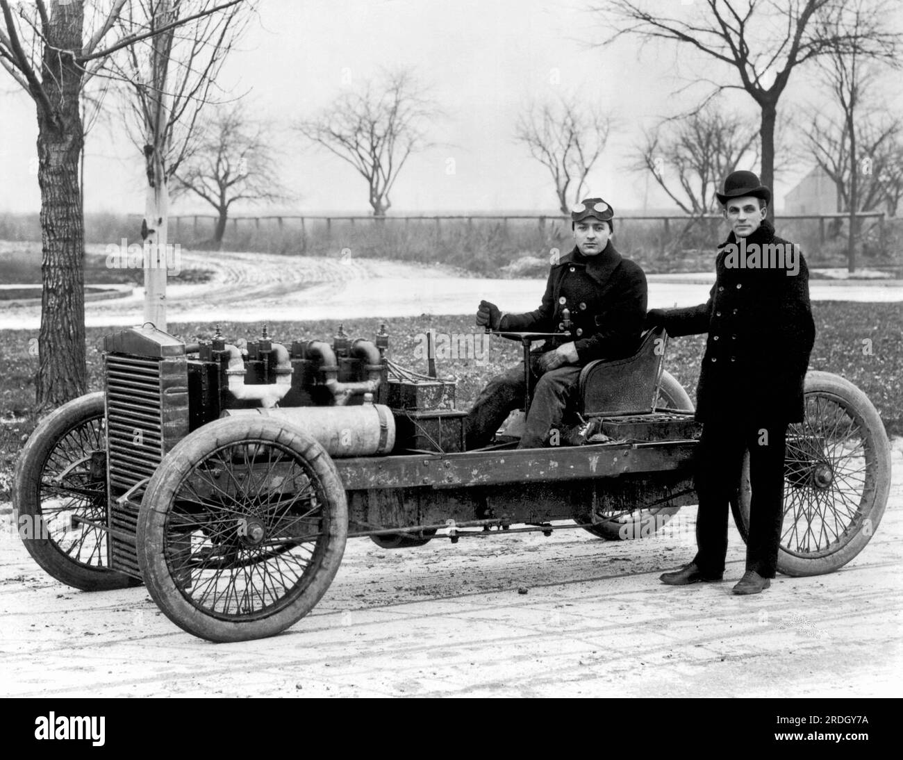 Grosse Pointe, Michigan: 1902 Rennfahrer Barney Oldfield in dem Rennwagen 999, den er von Henry Ford kaufte, der neben ihm stand. Stockfoto