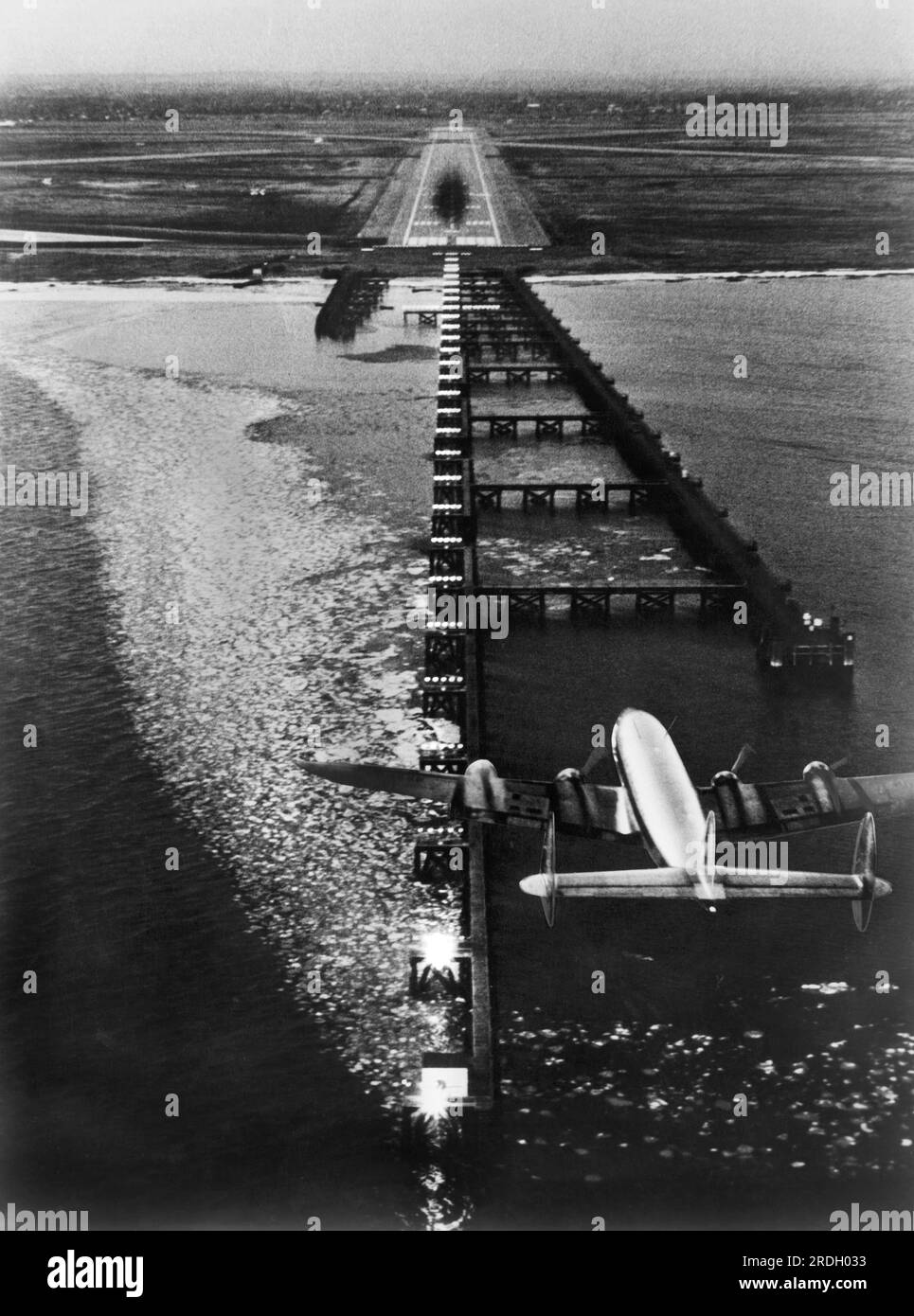 New York, New York: 12. Januar 1956 Dies ist das, was ein Pilot sieht, wenn er mit der neuen Sylvania Strobeacon-Beleuchtung bei eingeschränkter Sicht am Flughafen Idlewild landet. Das Stroboskop wird zünden, um den Piloten zur Landebahn zu führen. Die schwarze Markierung auf der Piste ist von den Reifen beim Aufsetzen. Stockfoto