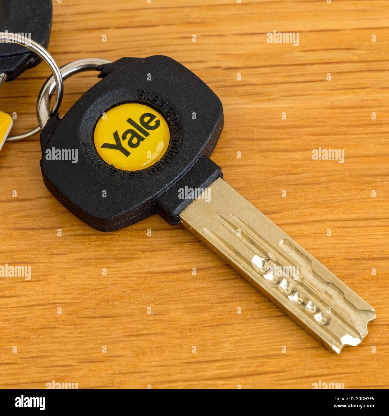 Ein hochsicherer Türschlossschlüssel mit Yale-Emblem auf Holztischfläche Stockfoto