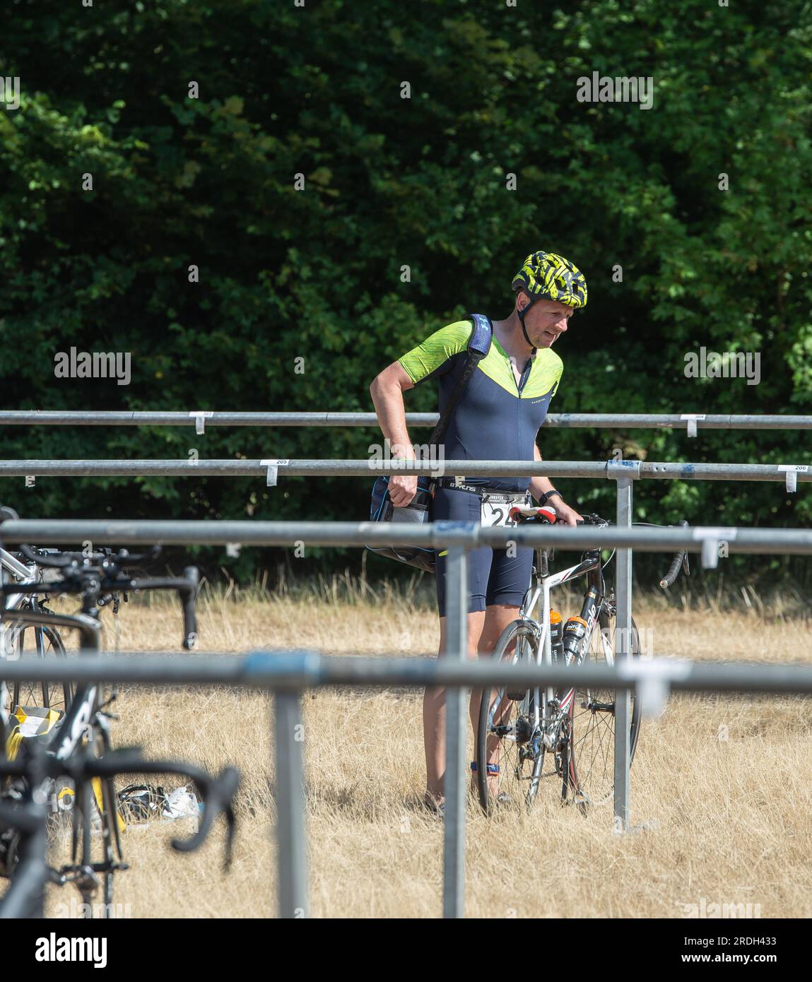 Voorst, Niederlande - Juni 25. 2023: Dieser Triathlet verlässt sein Motorrad im Übergangsbereich des Voorster Triathlon. Stockfoto