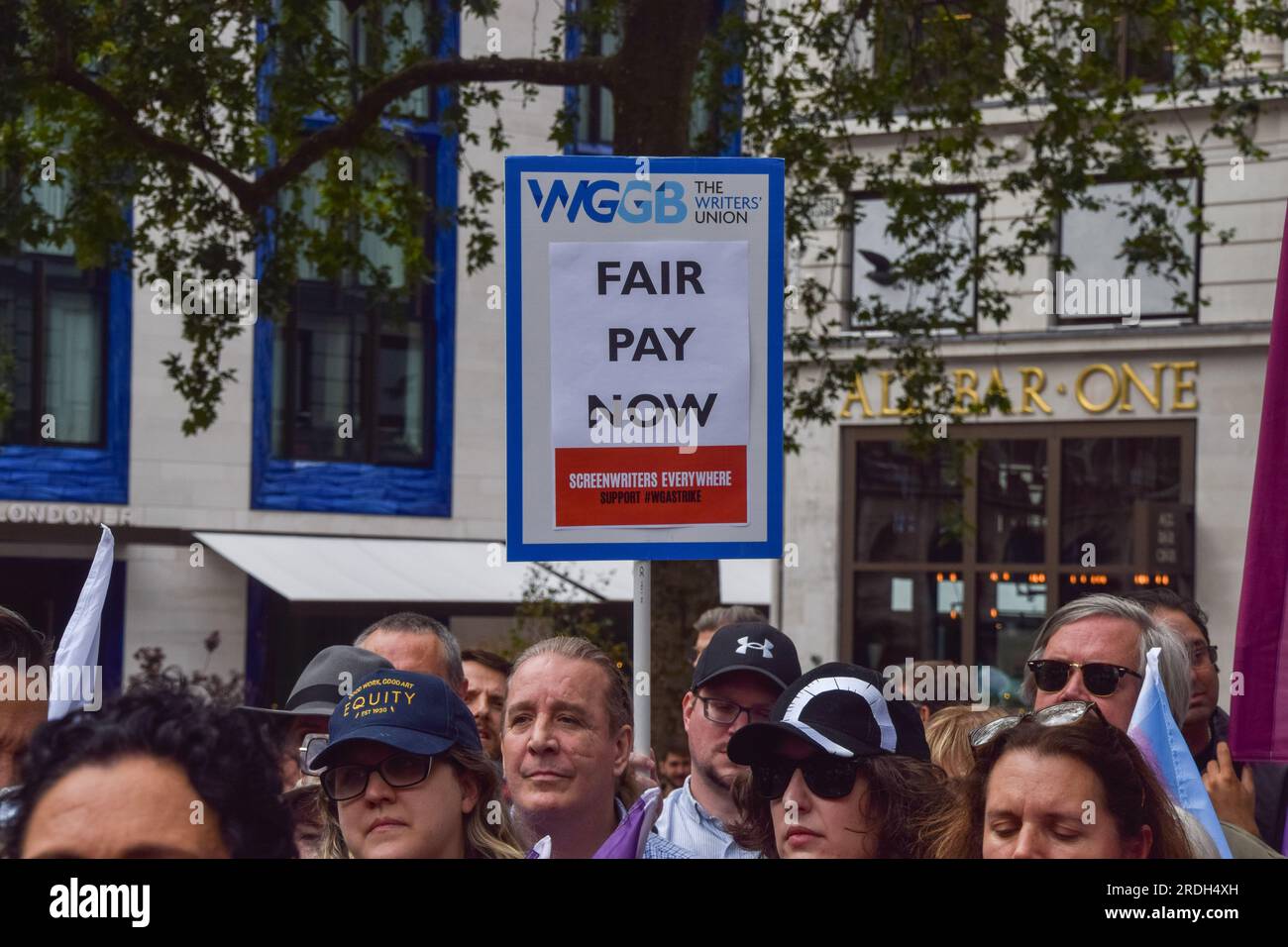 London, Großbritannien. 21. Juli 2023. Ein Protestteilnehmer hält ein Plakat zur Unterstützung einer fairen Bezahlung für Drehbuchautoren während der Demonstration. Die Gewerkschaft der darstellenden Künste und Unterhaltungsindustrie veranstaltete auf dem Leicester Square eine Kundgebung, die sich solidarisch mit dem Streik der sag-AFTRA (Screen Actors Guild - American Federation of Television and Radio Artists) zeigte. Kredit: SOPA Images Limited/Alamy Live News Stockfoto