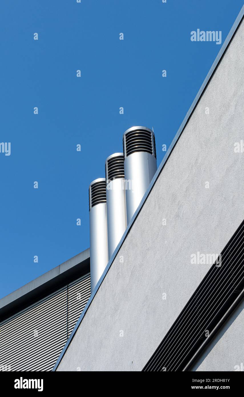 Villach, Österreich. 18. Juli 2023. Stahlschornsteine ragen aus einem Industriegebäude heraus Stockfoto