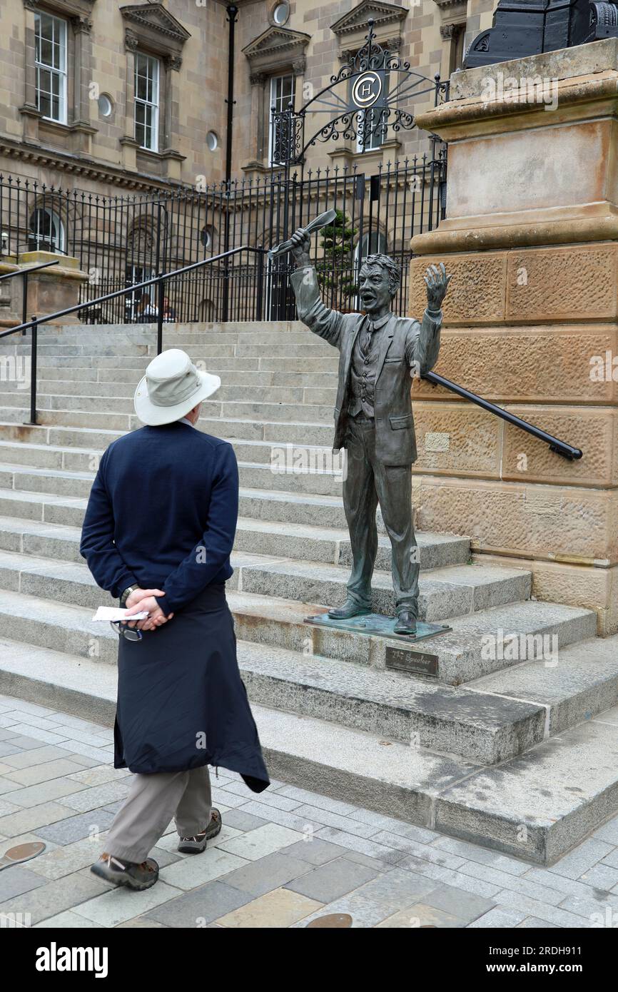 Tourist in Belfast mit der Skulptur von Gareth Knowles, der "Sprecher" genannt wird Stockfoto