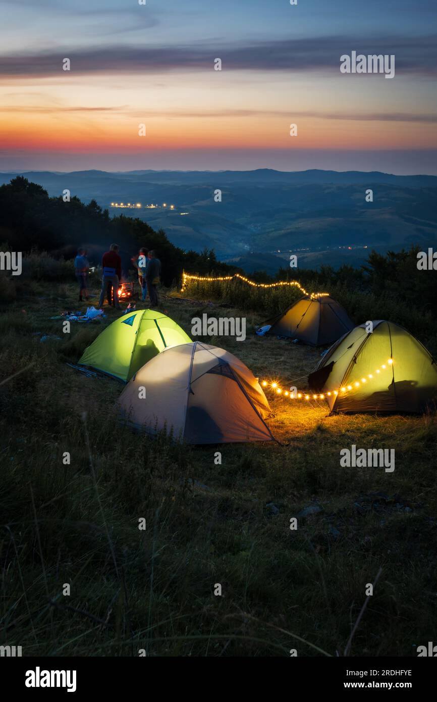 Am Abend beim Camping in den Bergen. Beleuchtete Zelte in einem malerischen Tal. Stockfoto