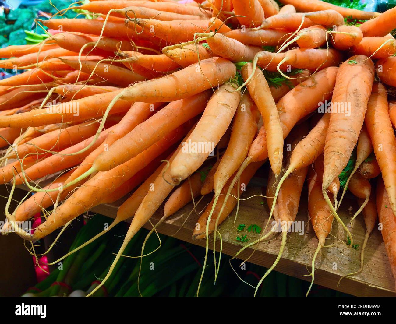 Ein Haufen frisch geernteter orangefarbener Karotten, die auf dem Bauernmarkt zum Verkauf stehen. Stockfoto