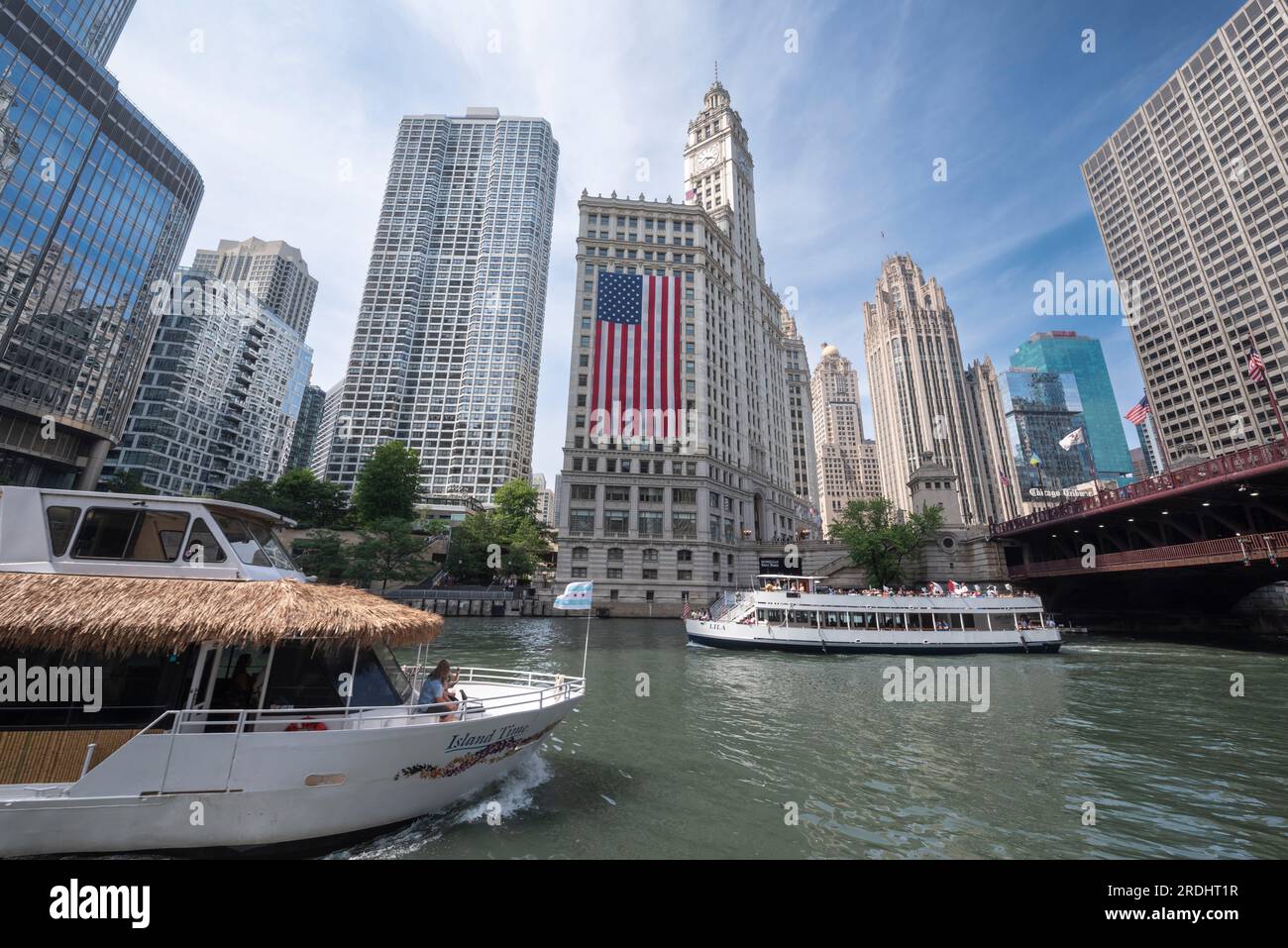 Blick auf die Innenstadt von Chicago mit Touristenbooten auf dem Fluss und einer riesigen amerikanischen Flagge vom Independence Day. Stockfoto