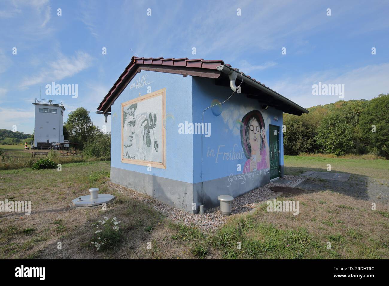 Innerdeutsche Grenze der ehemaligen DDR mit Aussichtsturm und Haus mit Graffiti und Slogan für Freiheit, Vacha, Thüringen, Deutschland Stockfoto