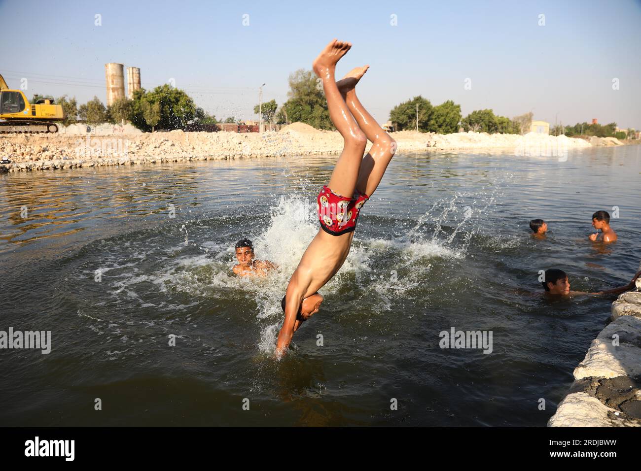 Gizeh, Ägypten. 21. Juli 2023. Ein Junge taucht in einen Kanal ein, um sich während einer Hitzewelle in Gizeh, Ägypten, am 21. Juli 2023 abzukühlen. Kredit: Ahmed Gomaa/Xinhua/Alamy Live News Stockfoto