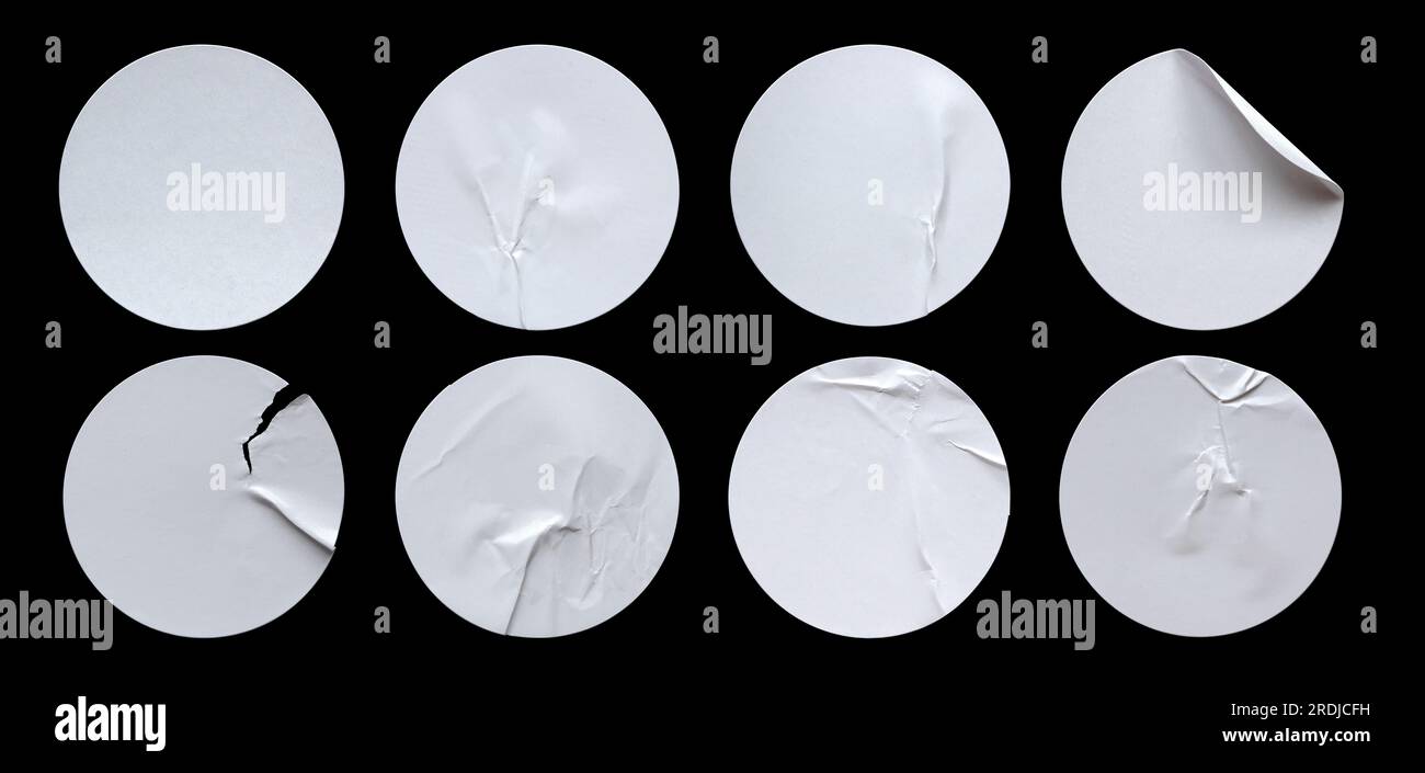 Ein Satz leerer, weißer, runder, selbstklebender Papieraufkleber, isoliert auf schwarzem Hintergrund. Stockfoto