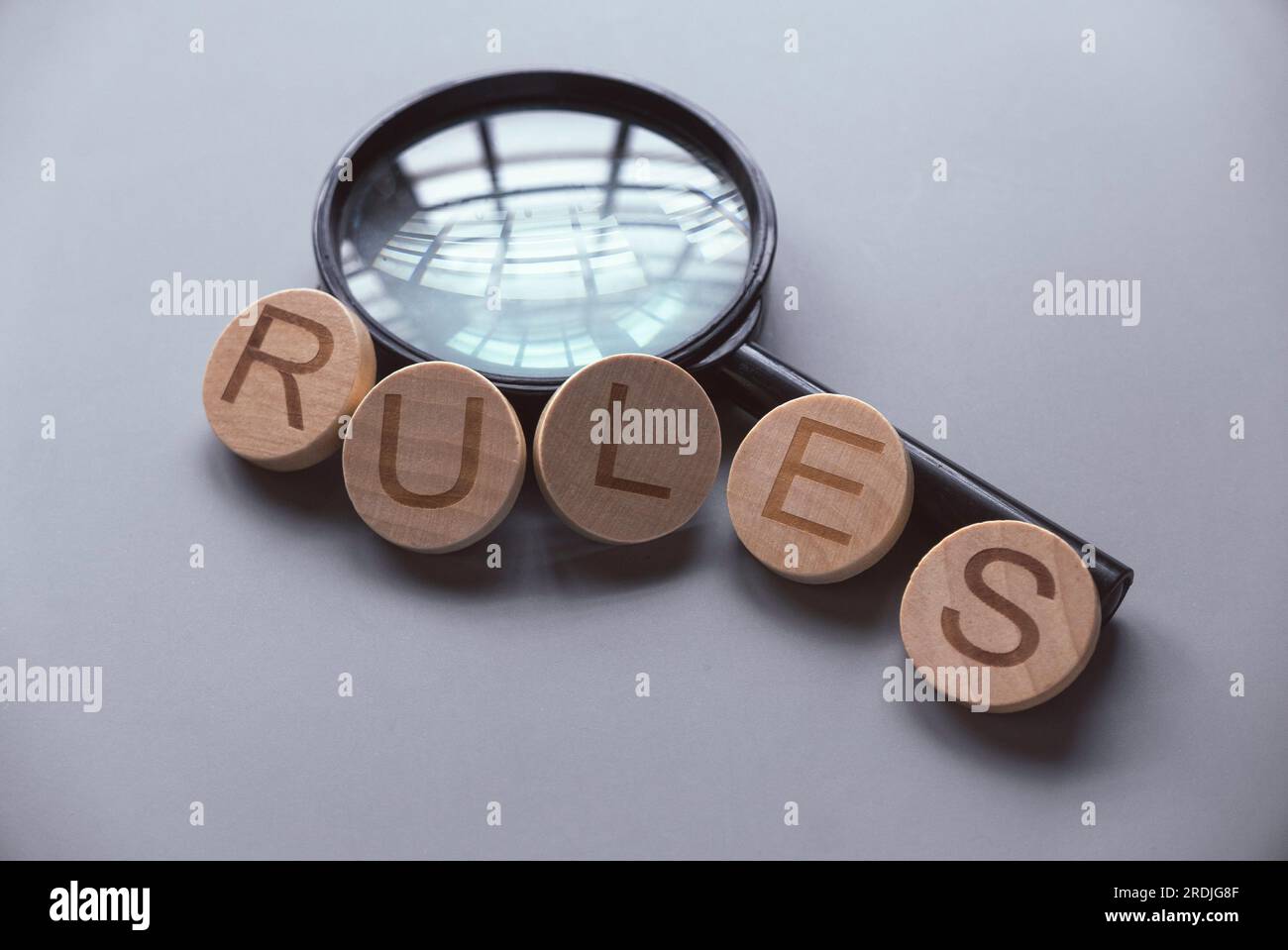 Ein hölzernes Alphabet von Wörtern beherrscht eine Lupe. Stockfoto