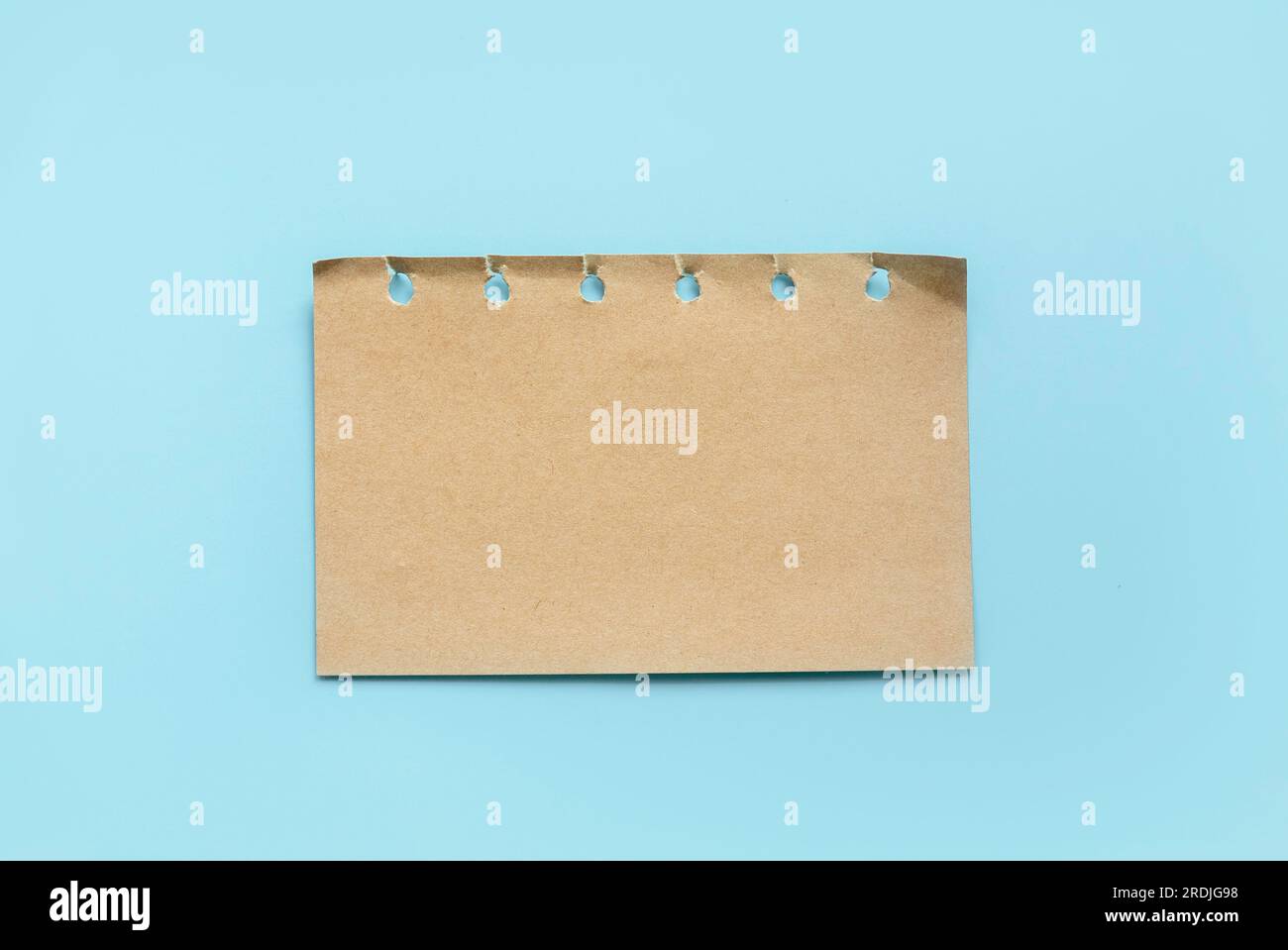 Braunes Notizpapier im Vintage-Stil, isoliert auf blauem Hintergrund. Stockfoto