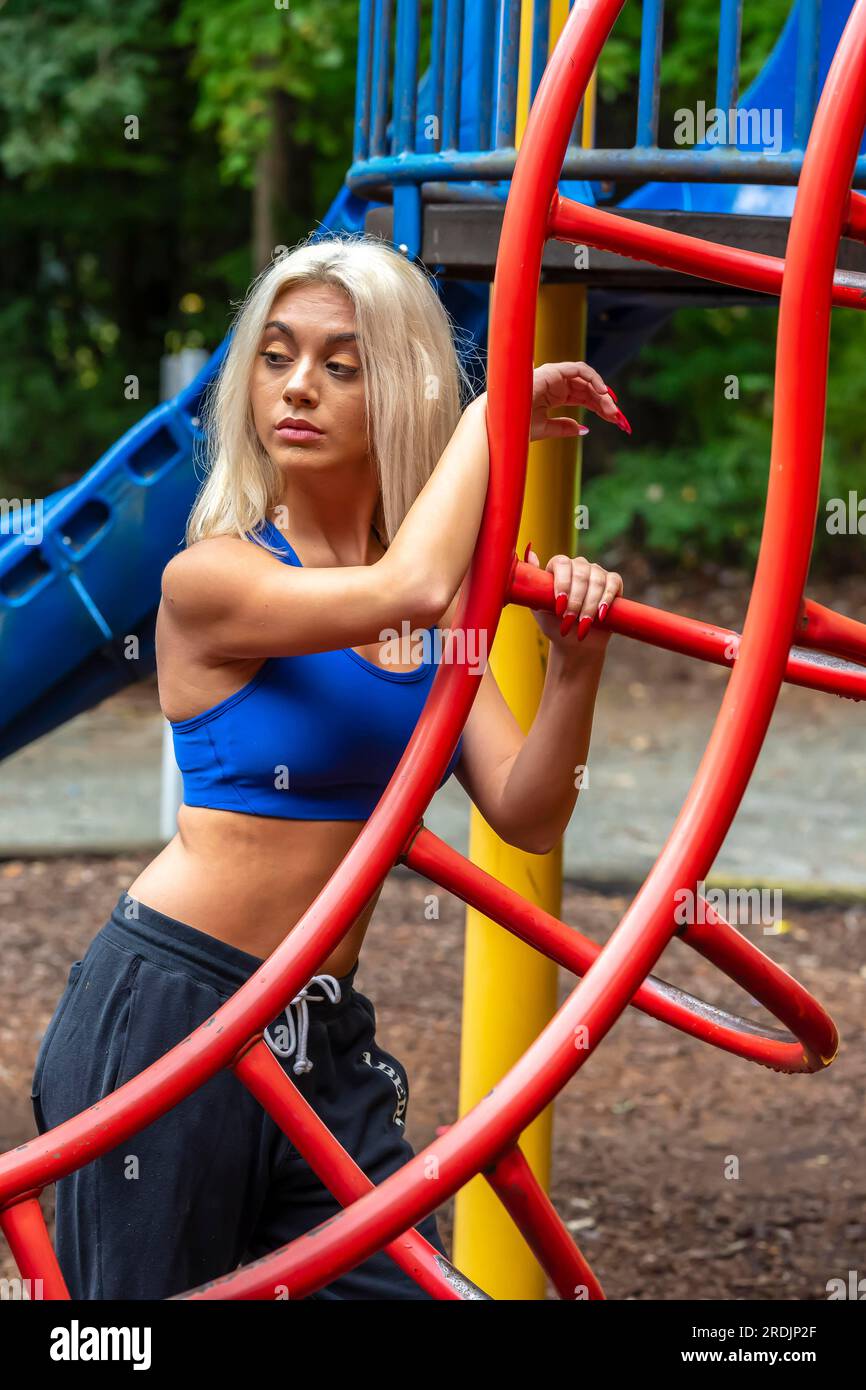 Ein prächtiges, blondes Model trainiert draußen und genießt einen Sommertag Stockfoto