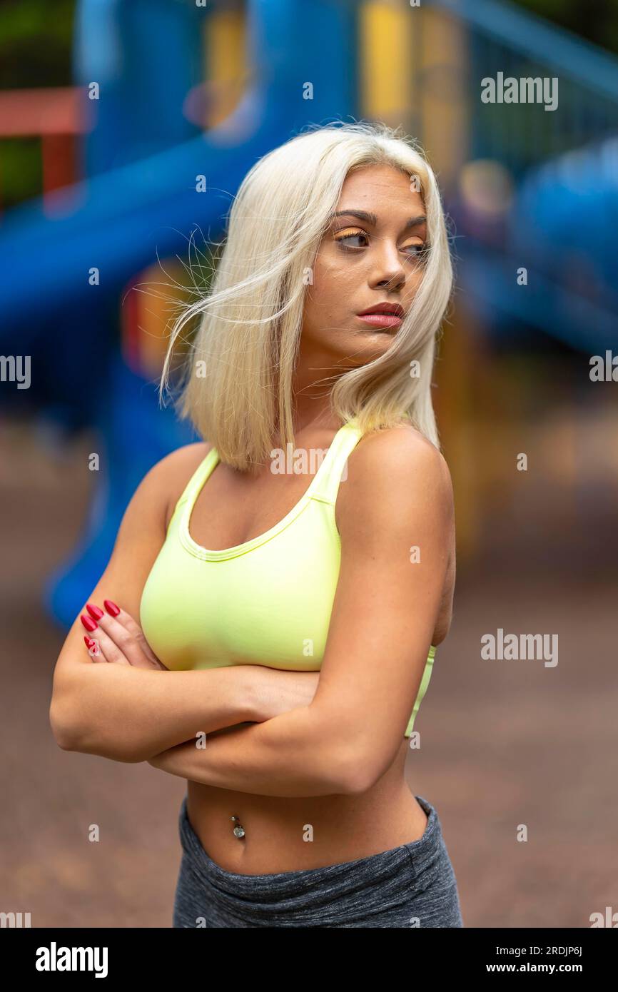 Ein prächtiges, blondes Model trainiert draußen und genießt einen Sommertag Stockfoto