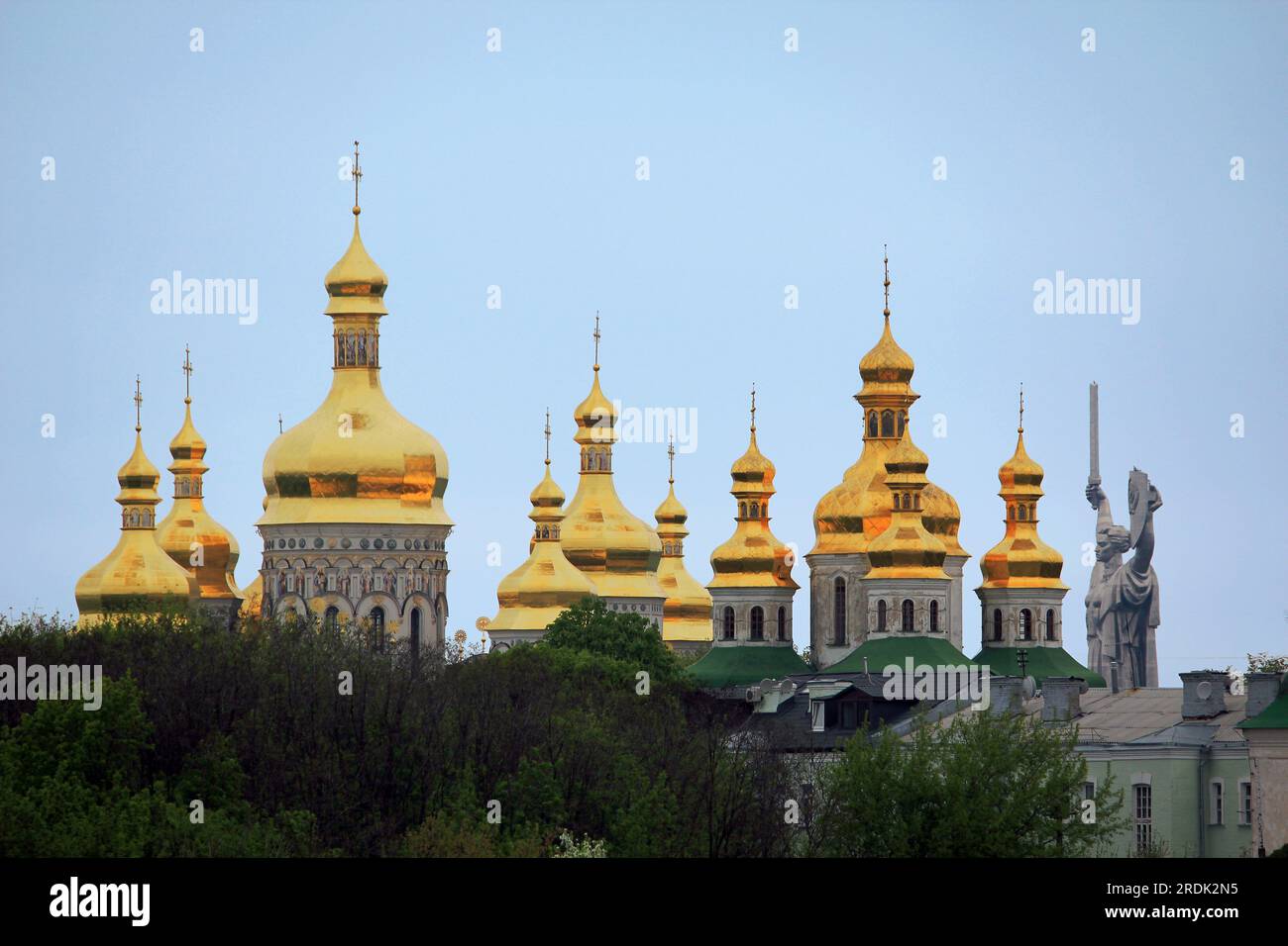 KIEW, UKRAINE - 3. MAI 2011: Dies sind die Kuppeln der Kirchengebäude der Lavra Kiew-Pechersk und das Monument des Mutterlands, das sich in der Nähe befindet. Stockfoto
