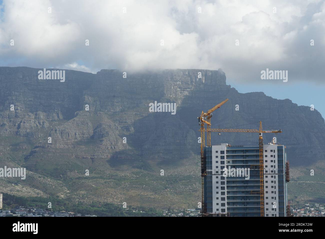 Tafelberg in Kapstadt unter den schweren Regenwolken, die vom Hafen des Frachtschiffes beobachtet werden. Stockfoto