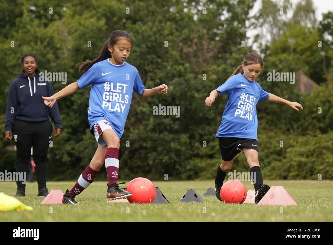 Junge Mädchen nehmen an der FA-Veranstaltung „Let Girls Play Big Football Day“ auf den Kings College Fields in Ruislip Teil. Let Girls Play Big Football Day ruft Basisvereine aus dem ganzen Land auf, sich zu beteiligen und den Start der England Women's World Cup Kampagne und die Entwicklung des Frauen- und Mädchenfußballs zu feiern. Bilddatum: Samstag, 22. Juli 2023. Stockfoto