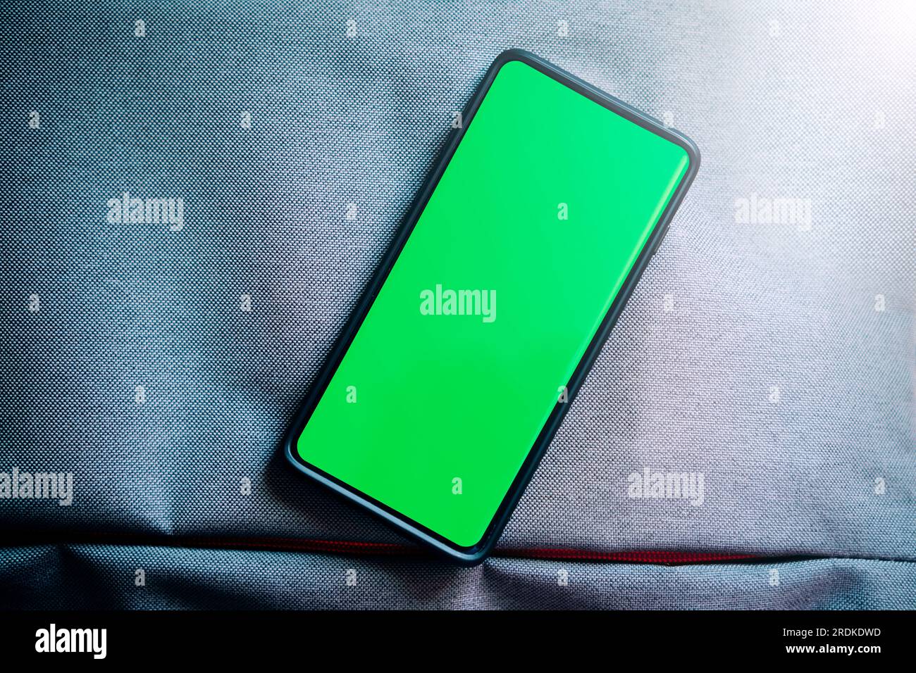Flach liegendes Foto des grünen Smartphone-Bildschirms. Chroma Key Telefonbildschirm in vertikaler Position. Fotomodell mit Kopierbereich. Internet der Dinge. Stockfoto
